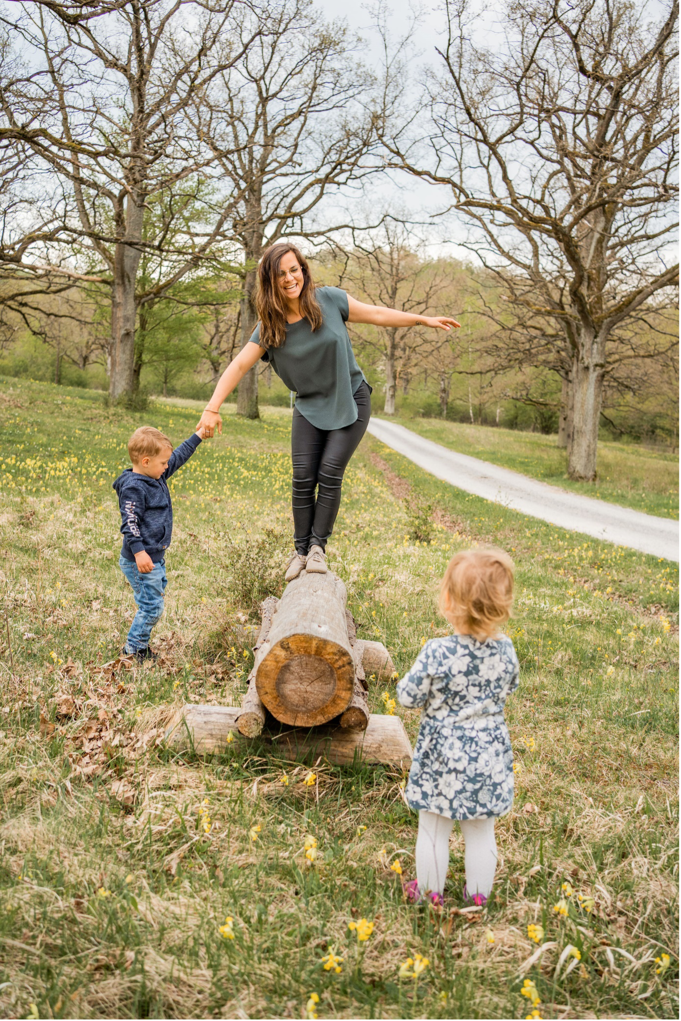 Ramona spielt mit Kindern und balanciert auf einem Holzbalken